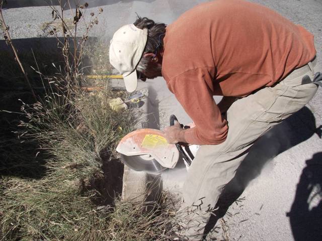 Using concrete saw to cut curb for water harvesting