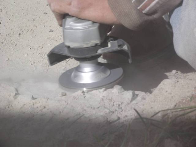 Using grinder to finishing shaping and smoothing curb cut